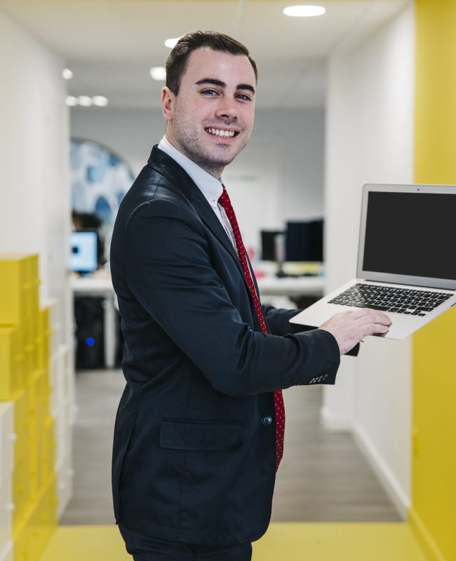 cheerful-man-using-laptop-office
